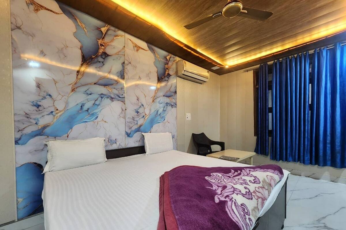 Quarto moderno com uma cama grande, uma escrivaninha e uma cortina azul.