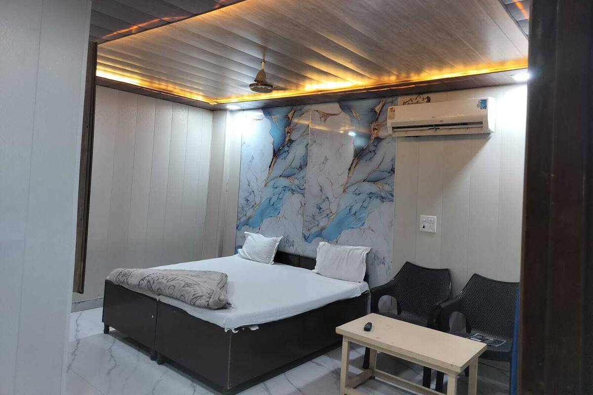 Um quarto com uma cama, uma mesinha e uma cadeira.