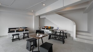 A modern interior with a central seating area, a staircase, and a kitchen counter.