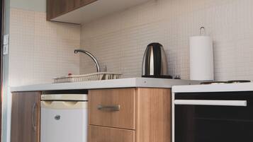 A modern kitchen with wooden cabinets, a white dishwasher, and a black microwave.
