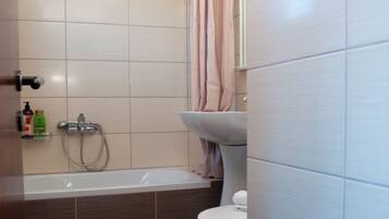 Un baño con bañera, inodoro y zona de ducha.