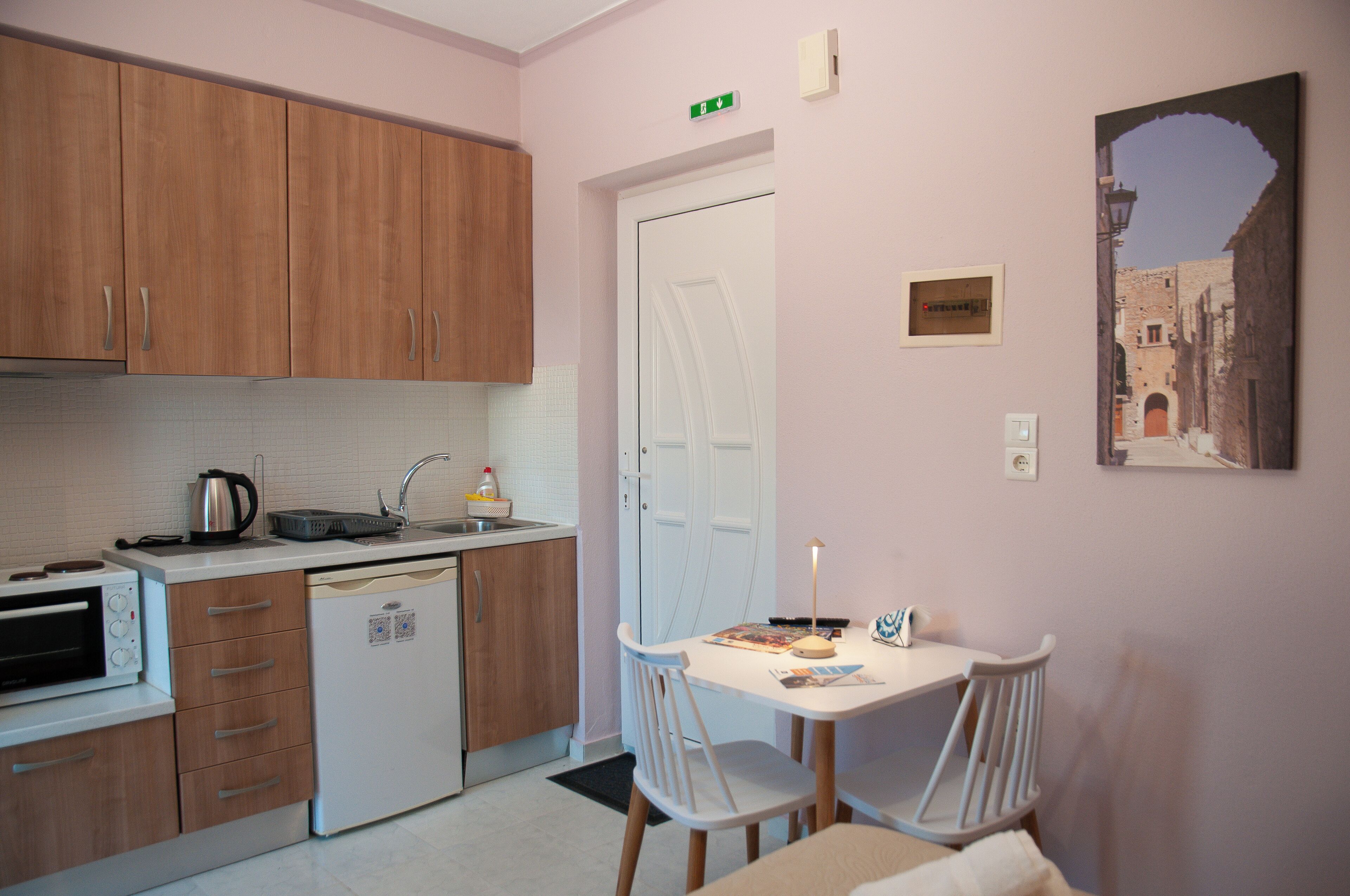 A compact kitchen with wooden cabinets, a built-in oven, and a small sink.