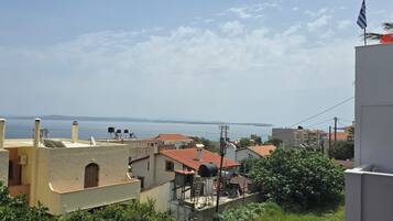 A coastal residential area with buildings, a clear sky, and the sea in the background.