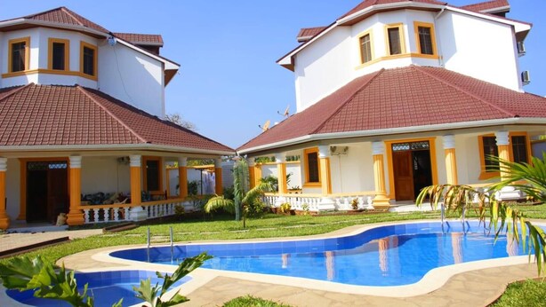Una casa de dos pisos con piscina delantera.