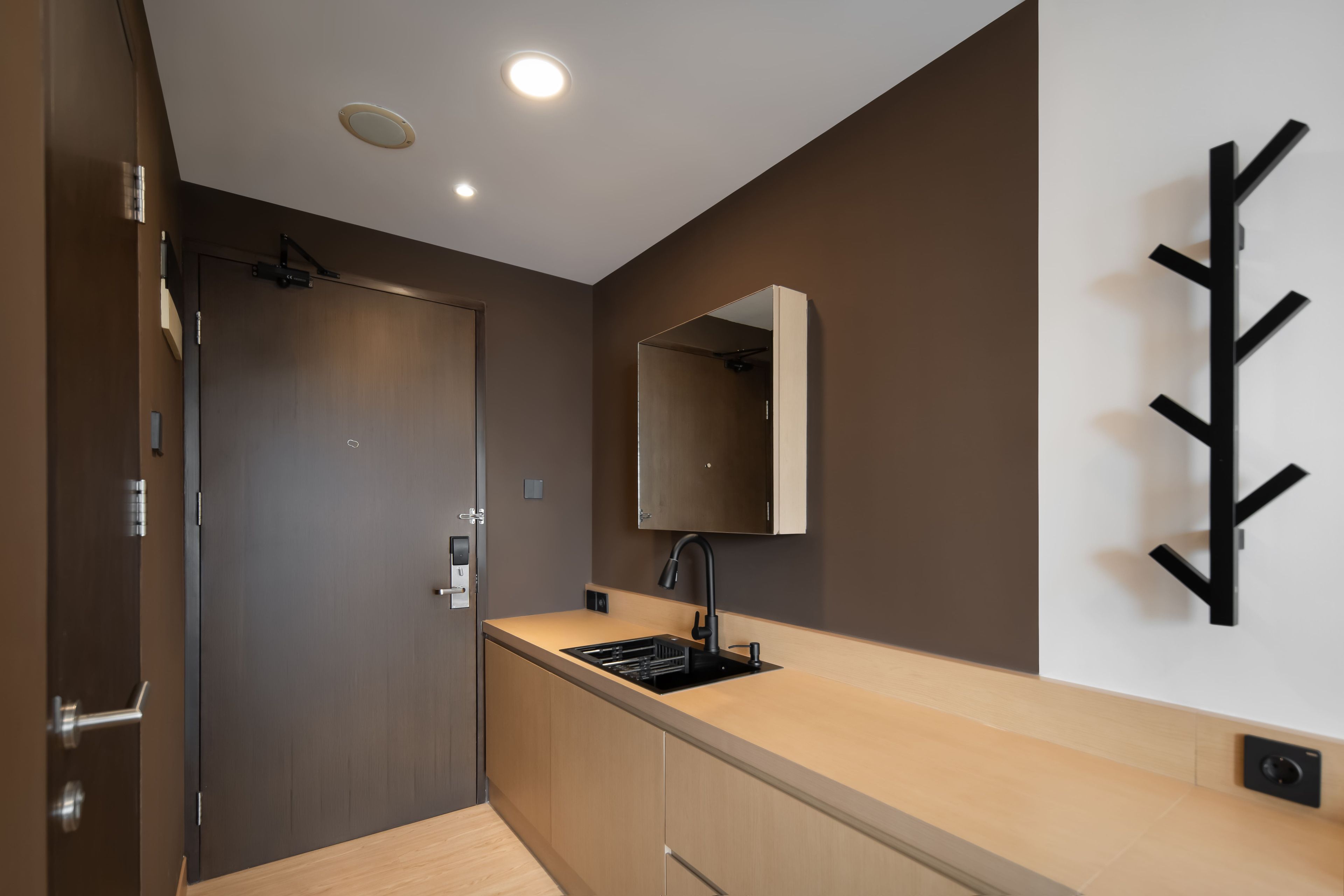 A modern kitchen with a built-in sink, a mirror, and a wall-mounted light fixture.