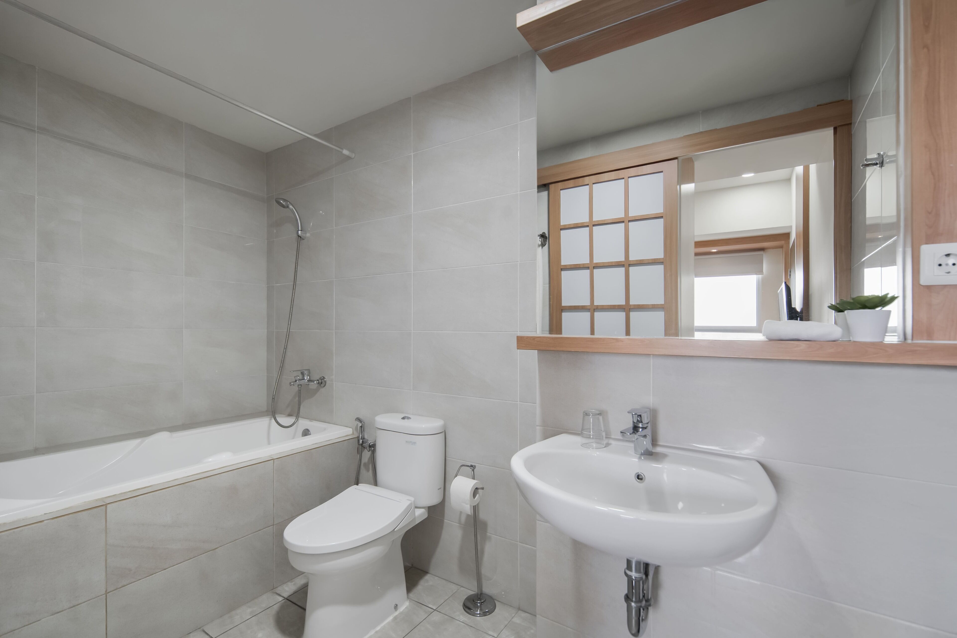 Une salle de bain moderne équipée d’une baignoire, de toilettes et d’un lavabo.