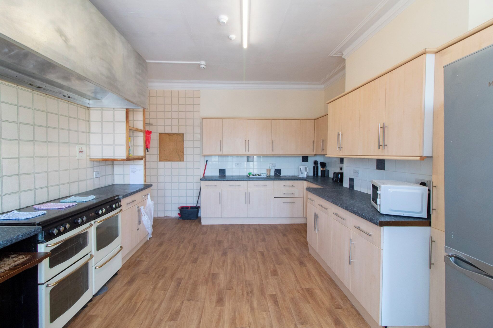 Una cocina con armarios de madera, un microondas, una estufa y un lavabo.