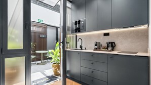 Una cocina moderna con microondas integrado, cafetera y lavabo.