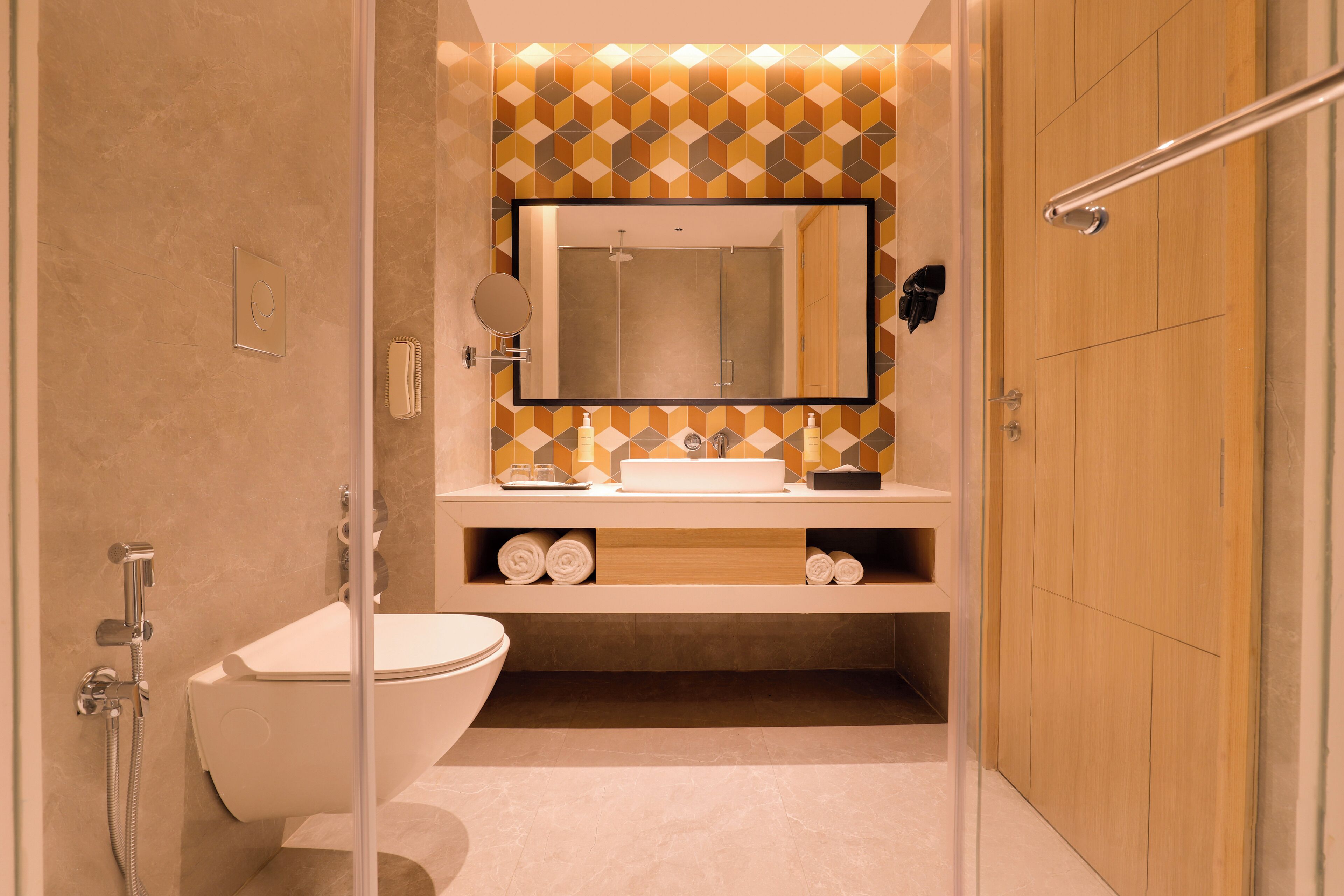 A modern bathroom with a glass shower enclosure, a white toilet, and a vanity with a mirror.