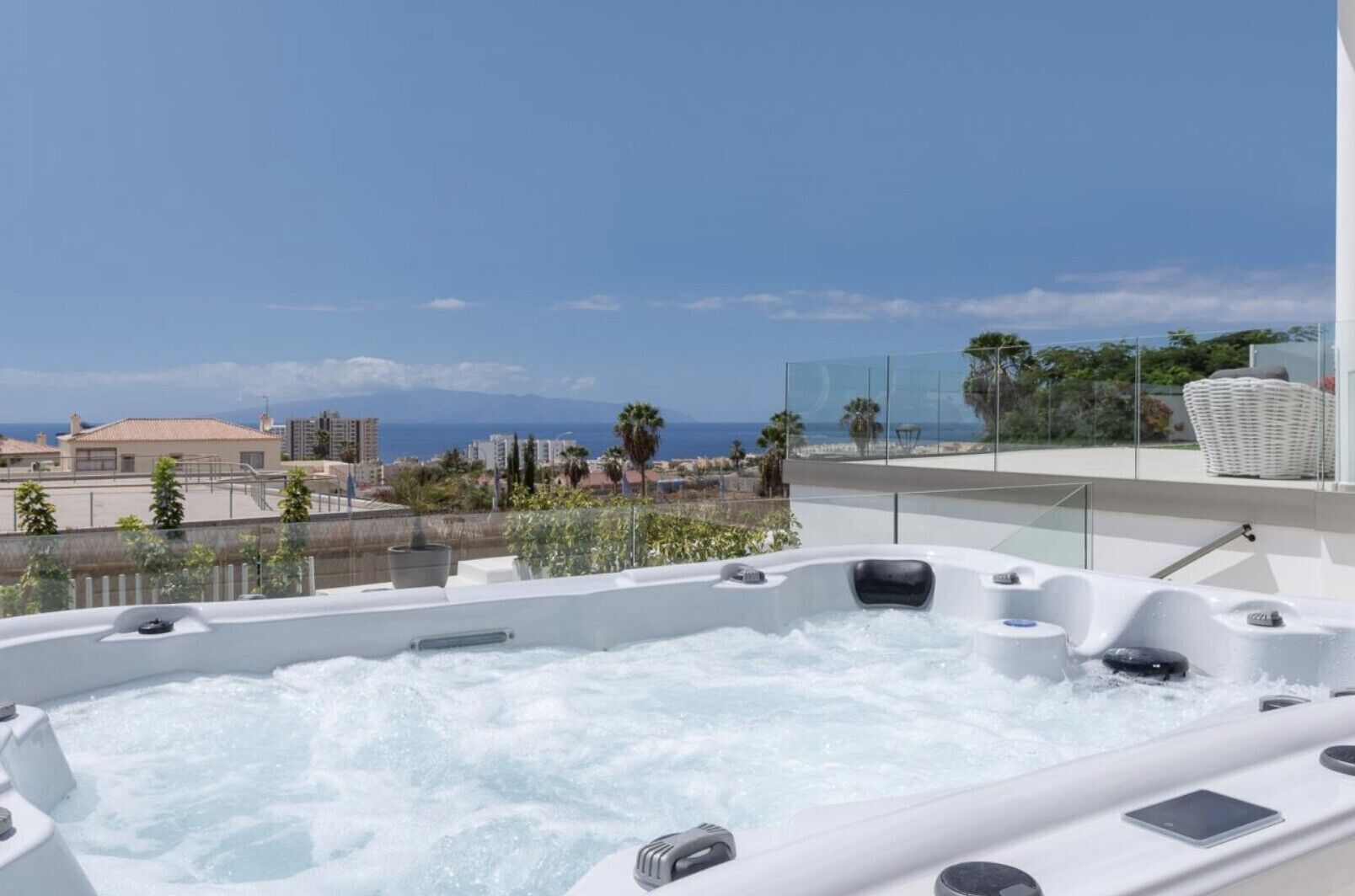 A rooftop jacuzzi with a clear view of the ocean and cityscape.