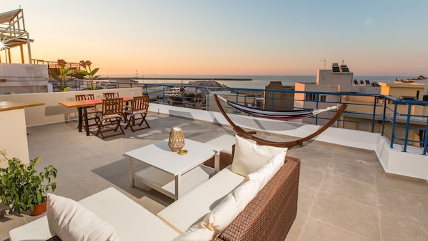 A rooftop terrace with a hammock, seating area, and a view of the sea. - Areti Seaview Residence (Rethymno)