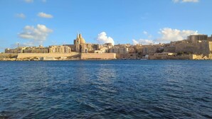 A coastal cityscape with historic buildings, a prominent church, and a fortified structure along the waterfront. - Modern 3 Bedroom Penthouse With Rooftop Views (Msida)
