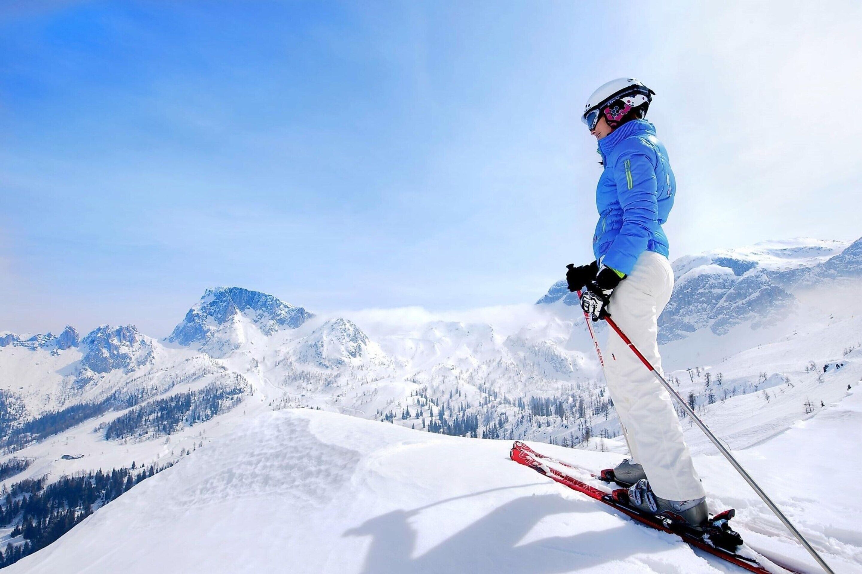 A person skiing on a snowy mountain with a clear sky.