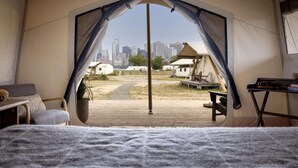 A tented accommodation with a view of a city skyline. - Island Glamping + Michelin dining & Skyline View (New York)