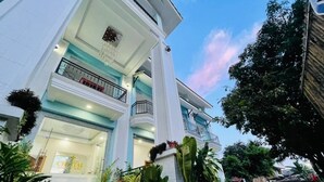 Ein Hotel mit einem imposanten Eingang, mehreren Stockwerken und einem Balkon.