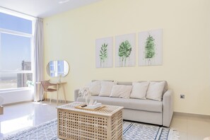 Een moderne woonkamer met een bank, een salontafel, een stoel en kunst aan de muur.