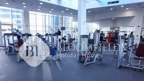 Ein geräumiger Fitnessraum mit verschiedenen Trainingsgeräten und großen Fenstern für natürliches Licht.