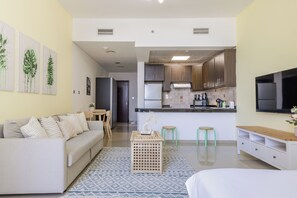 A modern living room with a sofa, coffee table, and a TV. - Bloomfileds Executive STU in Hydra (Abu Dhabi)