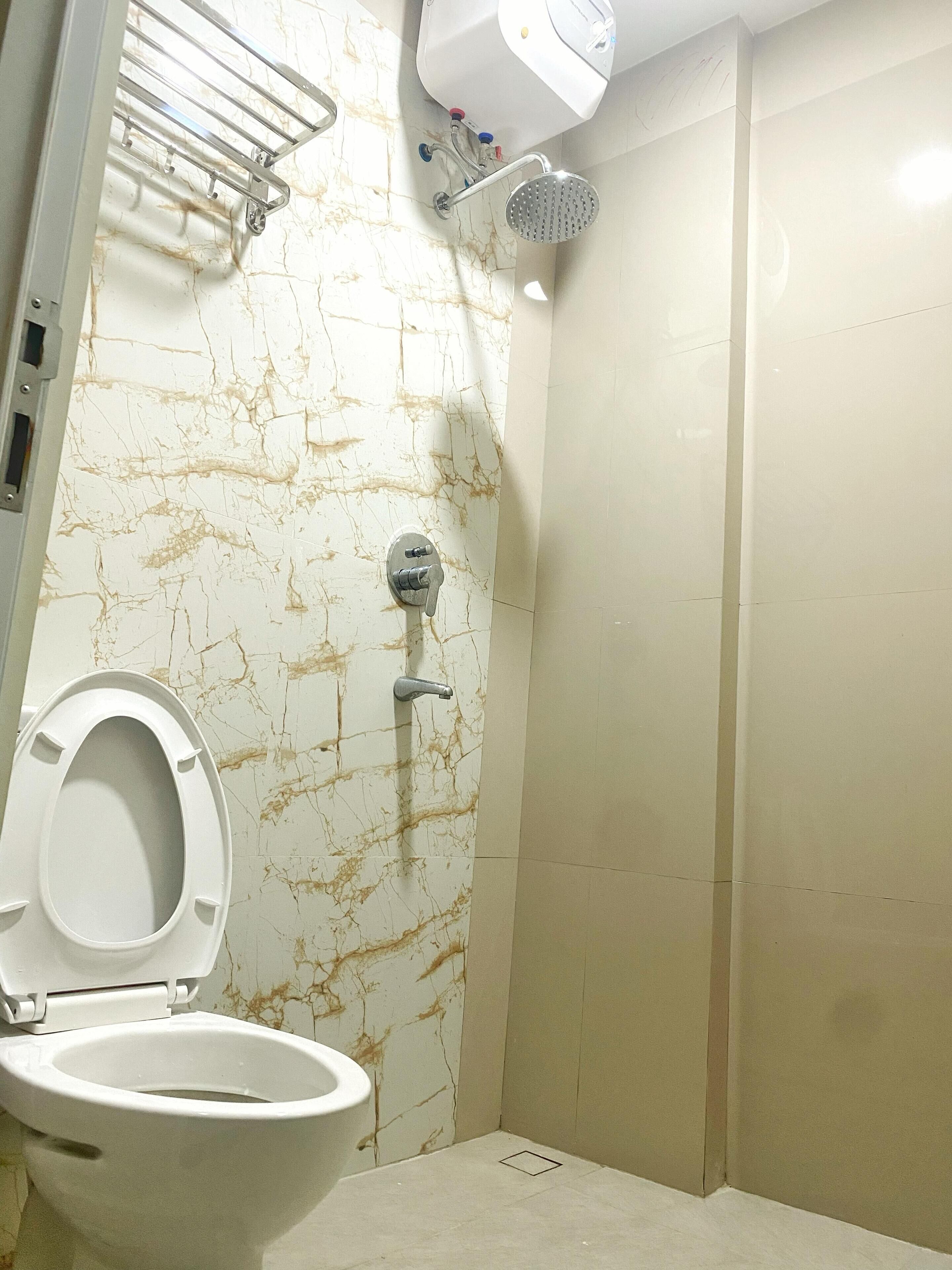 Un baño con inodoro, ducha y secador de manos.