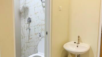 Un baño con inodoro, lavamanos y ducha.