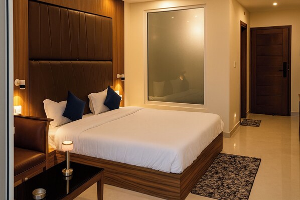 A modern hotel room with a large bed, wooden headboard, bedside tables, and a large window.