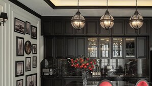 A modern kitchen with dark cabinetry, a marble countertop, and a central island with red chairs.