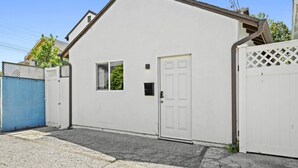 A single-story building with a white exterior, a small window, and a door.