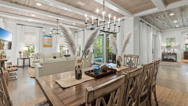 A spacious living room with a wooden dining table, white sofas, and a chandelier. - Welcome to Azalea Abbey! Private Pool, Golf Cart, Walk to Beach, Seaside (Santa Rosa Beach)