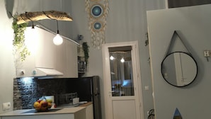 A modern kitchen with a central island, pendant lighting, and decorative wall art. - Boho Sisi Haven- Poolside Oasis Garden Retreat (Agios Nikolaos)