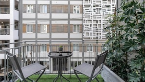 A balcony with two chairs and a small table, surrounded by a metal railing. - Acropolis Museum Apartment by A&A Residences (Athens)