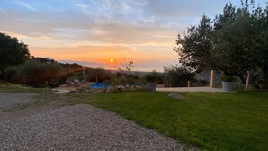 A backyard with a swimming pool, a lawn, and a view of the sunset over the water. - Tenute Lomasi - near Cefalù with swimming pool (Lascari)