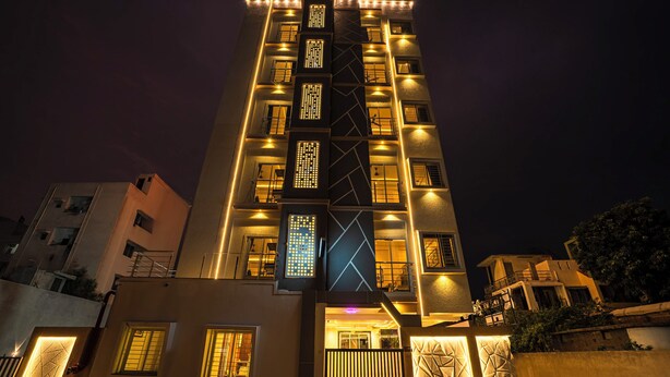 Um edifício de vários andares com janelas iluminadas e design de fachada geométrica.