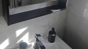 Ein Badezimmer mit Waschbecken, Spiegel und Dusche.