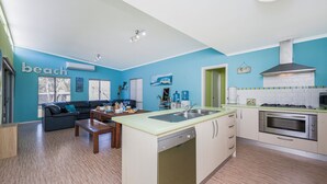A compact living space with a kitchen, a dining area, and a sofa. - Break-A-Way COASTAL COMFORT IN LANCELIN (Lancelin)