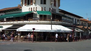 Un edificio con un letrero que dice "Café de Paris" y varios letreros de restaurante debajo.