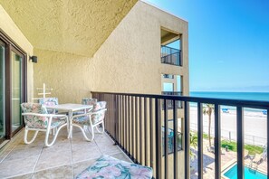 A balcony with a table and chairs, a pool, and a view of the beach. - **2 bed, 2 bath Direct Gulf Front Unit at The Shores**Stunning Views** (Redington Shores)