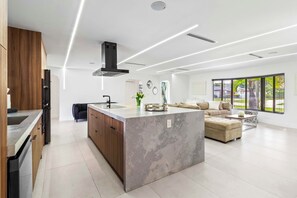 Una cocina moderna con una isla central, armarios de madera y lavavajillas integrado.