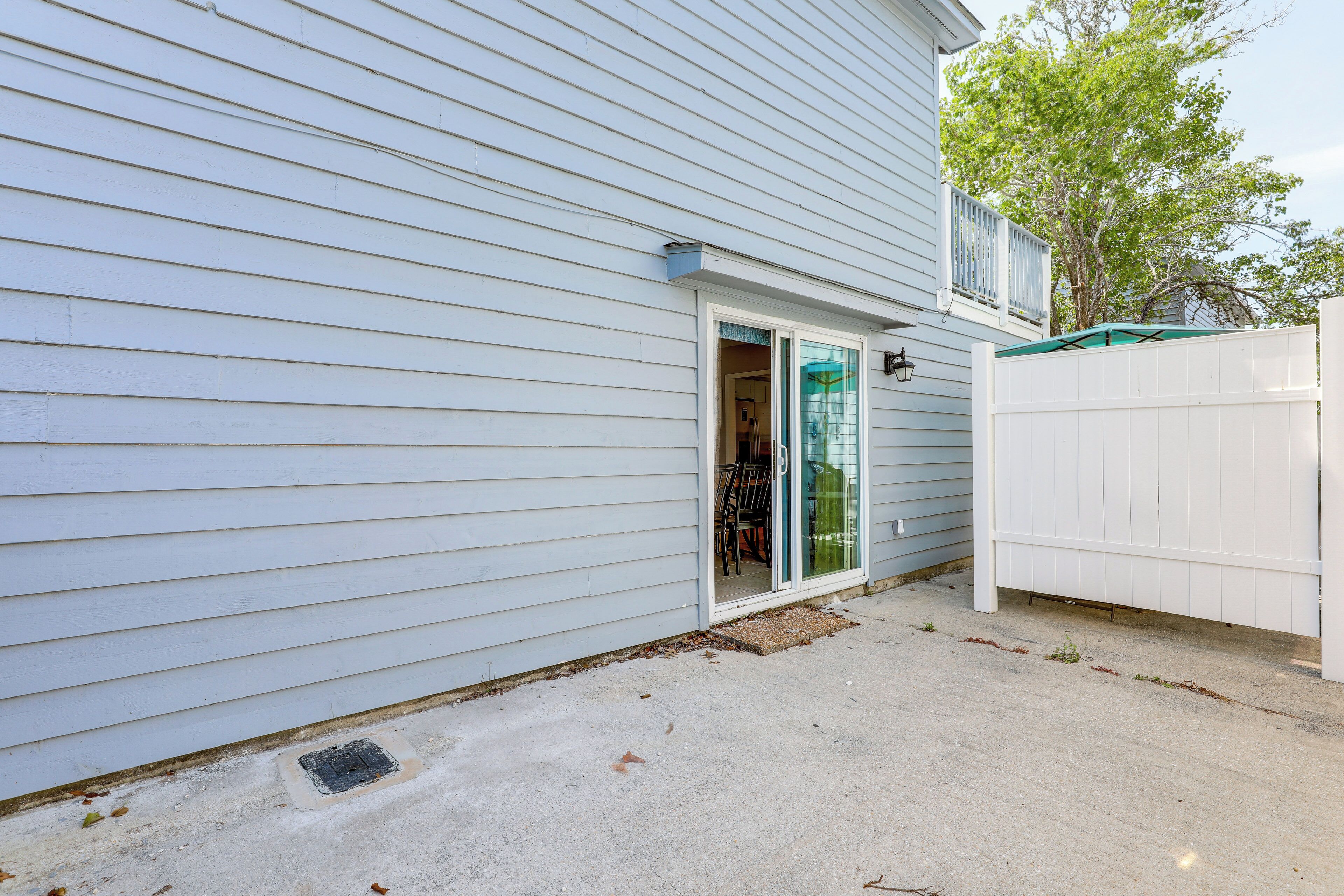 A house with a sliding glass door leading to a covered patio area.
