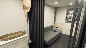 A modern bedroom with a grey sofa, a white dresser, a woven basket, and a grey patterned rug. - Central apartment - perfect base for nature, culture and cities (Soest)