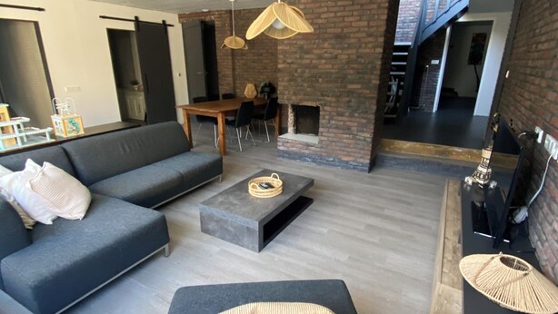 A modern living room with a sectional sofa, a coffee table, and a fireplace. - Central apartment - perfect base for nature, culture and cities (Soest)