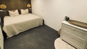 A bedroom with a bed, a dresser, and a nightstand. - Central apartment - perfect base for nature, culture and cities (Soest)