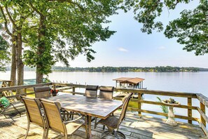 A wooden deck with a table and chairs overlooking a lake. - Boat Ramp & Dock: Lake Greenwood Getaway! (Cross Hill)