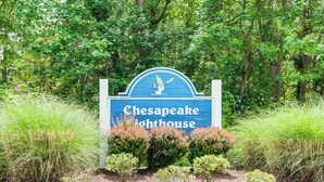 A sign for Chesapeake Lighthouse surrounded by lush greenery. - 1 Mi to Boardwalk: Convenient North Beach Apt! (Owings)