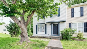 A two-story house with a front porch, a tree in the yard, and a well-maintained lawn. - 1 Mi to Boardwalk: Convenient North Beach Apt! (Owings)