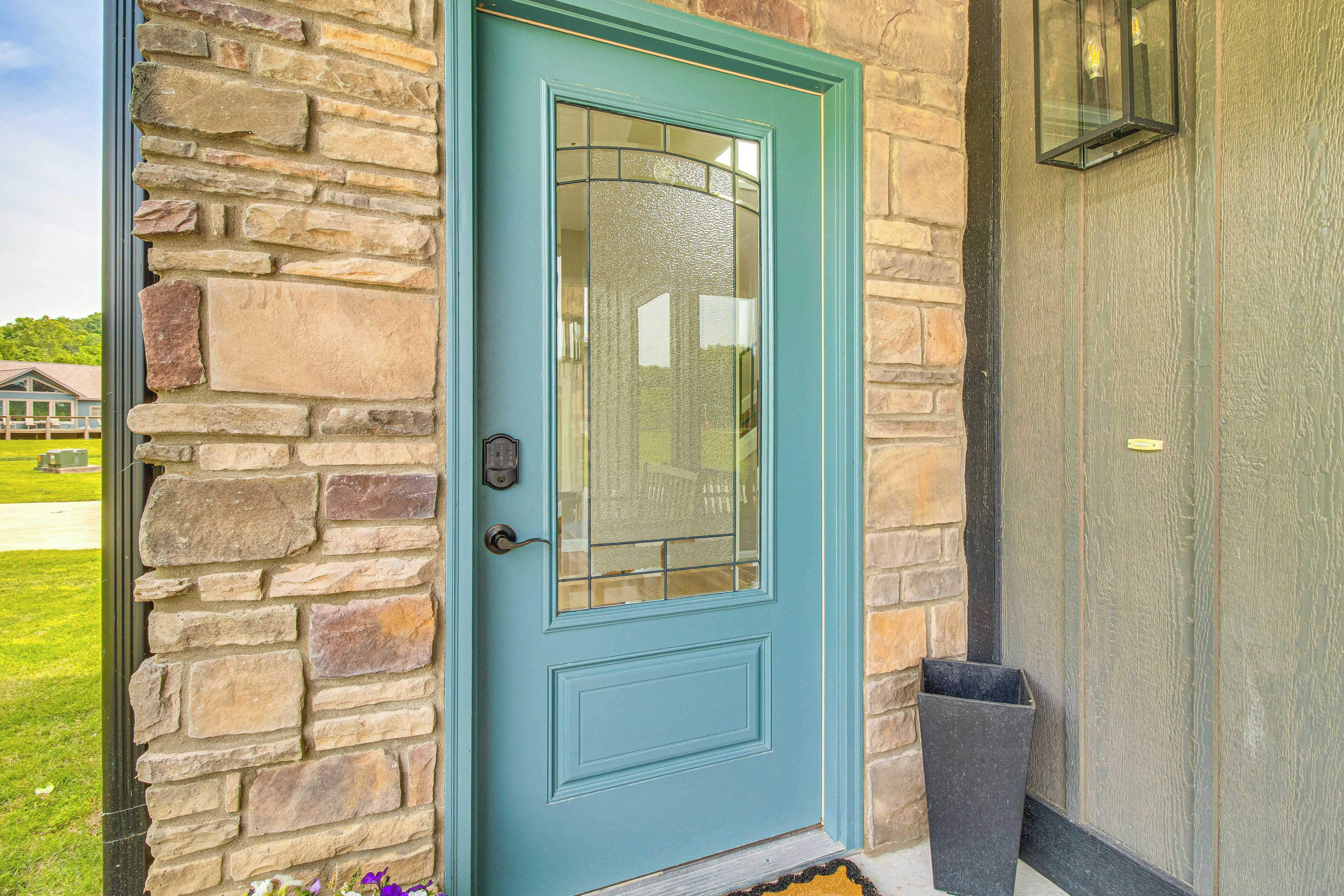 A turquoise door with a glass panel, set in a stone wall.