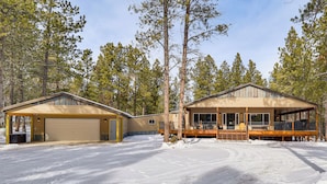 A two-story cabin with a garage, a covered porch, and a deck. - Black Hills Vacation Lodge: New Home! Just Opened! (Newcastle)
