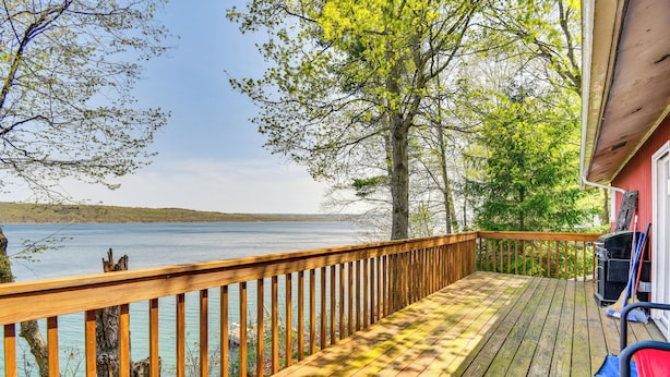 A wooden deck with a view of a lake, a grill, and a chair. - < 1 Mi to State Park: Trumansburg Cottage w/ Deck! (Trumansburg)