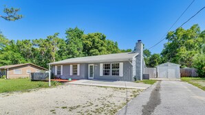 A single-story house with a front porch, a garage, and a well-maintained lawn. - Homosassa Getaway w/ Pool & Refreshed Lanai (Homosassa)