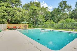 A rectangular swimming pool with a tiled edge, surrounded by a fence and trees. - Homosassa Getaway w/ Pool & Refreshed Lanai (Homosassa)
