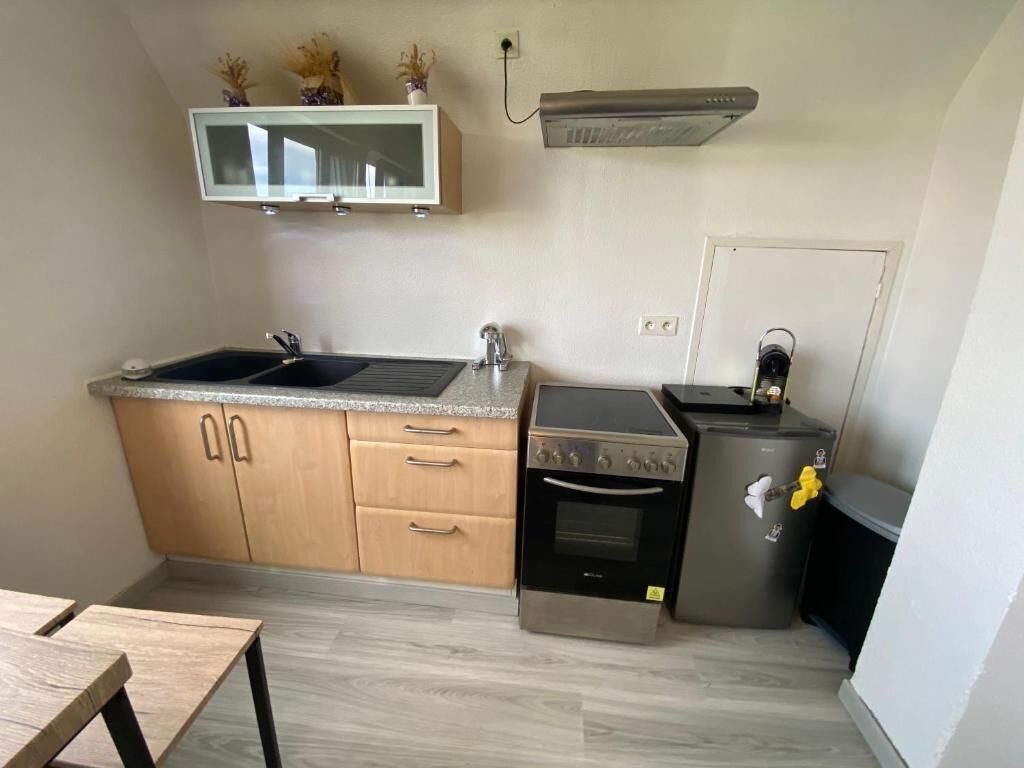 A compact kitchen with a double sink, a built-in oven, and a refrigerator.